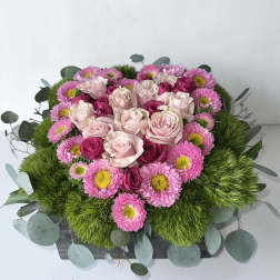 Pink roses and daisies arranged in a low rectangular box
