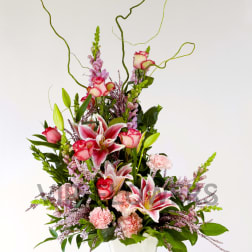 Tall pink and white floral arrangement in a white vase