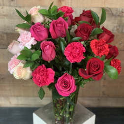 Bouquet of pink and red roses with carnations in a glass vase