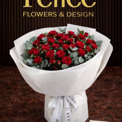 Bouquet of red roses wrapped in white paper with a ribbon