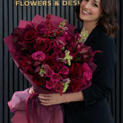 Woman holding a large bouquet of deep pink and red roses
