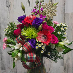 Colorful mixed bouquet in a glass vase with a plaid ribbon