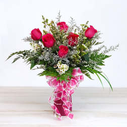 Pink roses in a vase with a decorative ribbon