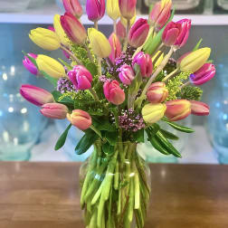 Bouquet of pink and yellow tulips in a glass vase