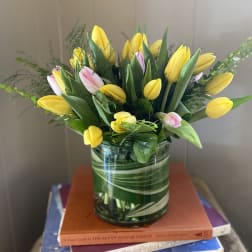 Yellow and pink tulips arranged in a glass vase