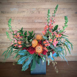 Colorful floral arrangement in a textured blue vase with tall pink spikes