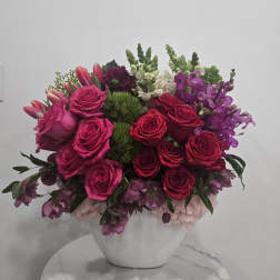 Pink and red rose arrangement in a white vase