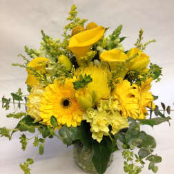 Yellow floral arrangement in a clear glass vase