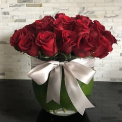 Bouquet of red roses in a glass vase with a satin ribbon