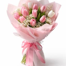 Pink and white tulip bouquet wrapped in pink paper with a ribbon