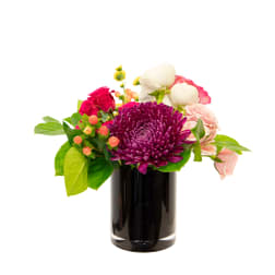 Compact arrangement with purple chrysanthemum, pink and white blooms in a black glass cylinder vase