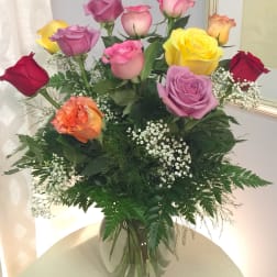 Mixed roses in a clear glass vase with baby's breath