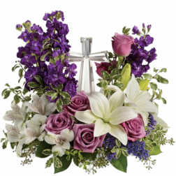 Purple and white floral arrangement with roses, lilies, and a silver cross