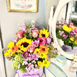 Colorful mixed bouquet in a lavender hat box with a ribbon