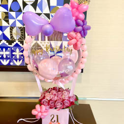 Birthday balloon display with pink roses in a gift box