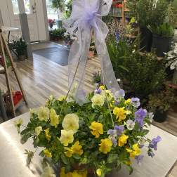 Basket of yellow and lavender pansies with a sheer purple bow