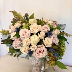 Bouquet of pale pink and cream roses in a textured vase