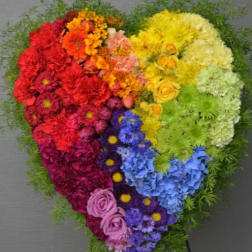 Heart-shaped rainbow floral arrangement on a stand
