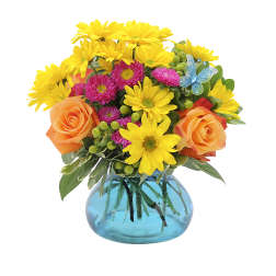 Bouquet of yellow daisies and orange roses in a blue glass vase