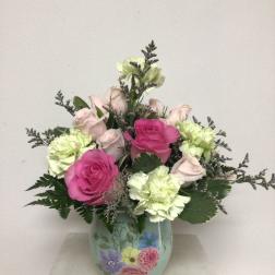 Pink and pale green roses with carnations in a painted vase