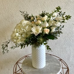 White floral arrangement in a textured white vase