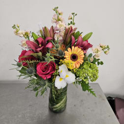 Mixed bouquet in a glass vase with pink, white, yellow, and green flowers