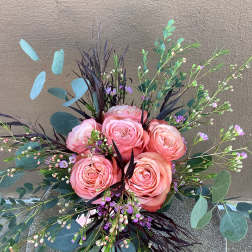 Pink roses arranged with eucalyptus and purple filler flowers