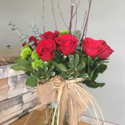 Bouquet of red roses in a glass vase with burlap wrap