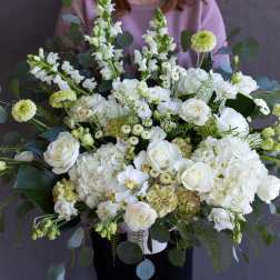 Large white floral arrangement with roses and hydrangeas