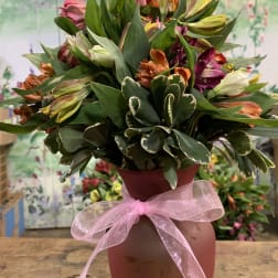 Mixed bouquet in a pink vase with a pink ribbon
