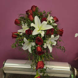 Red roses and white lilies arranged in a tall bouquet