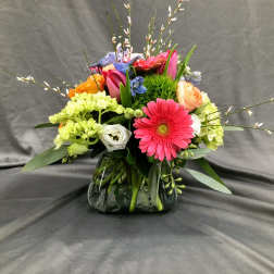 Colorful mixed bouquet in a glass vase with a pink gerbera daisy