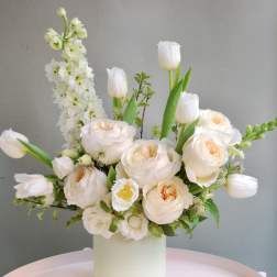Cream bouquet with tulips and roses in a white vase