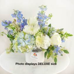 Blue and white floral arrangement in a white vase
