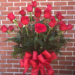 Tall bouquet of red roses with a large red ribbon