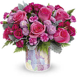 Pink roses and carnations arranged in a patterned glass vase