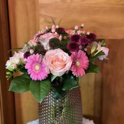 Pink and magenta flower arrangement in a textured vase