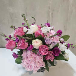 Pink and white rose bouquet with hydrangea in a glass vase