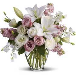 Bouquet of white lilies and pink roses in a clear glass vase