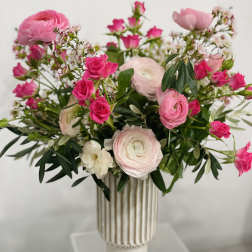 Pink and white flowers arranged in a tall striped vase