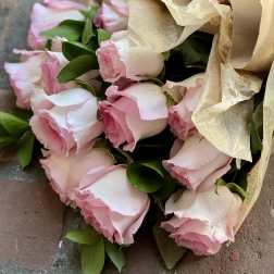 Bouquet of pale pink roses wrapped in tan paper