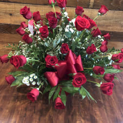 Large bouquet of red roses with greenery and a red ribbon