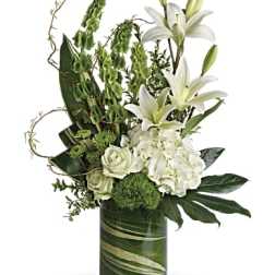 White lilies and roses arranged in a green glass vase