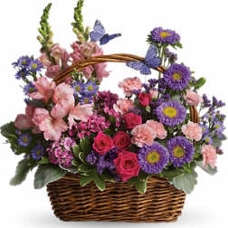 Basket arrangement of pink roses and carnations with purple asters and decorative butterflies