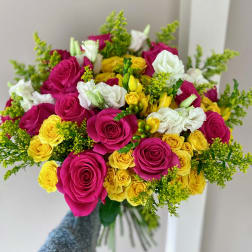 Handheld bouquet of pink, yellow, and white roses