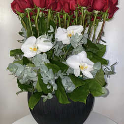 Red roses and white orchids arranged in a black vase