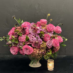 Pink rose and orchid arrangement in a ribbed vase