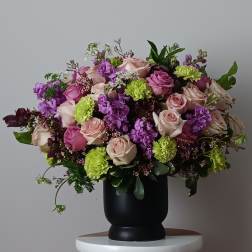 Large bouquet of pink and purple roses in a black vase