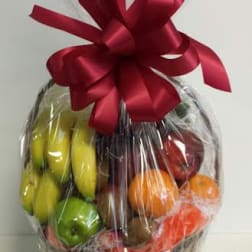 Basket of assorted fruit wrapped in cellophane with a red bow