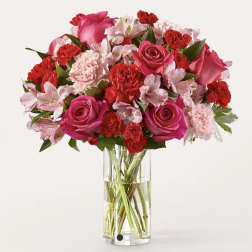 Bouquet of pink and red flowers in a clear glass vase